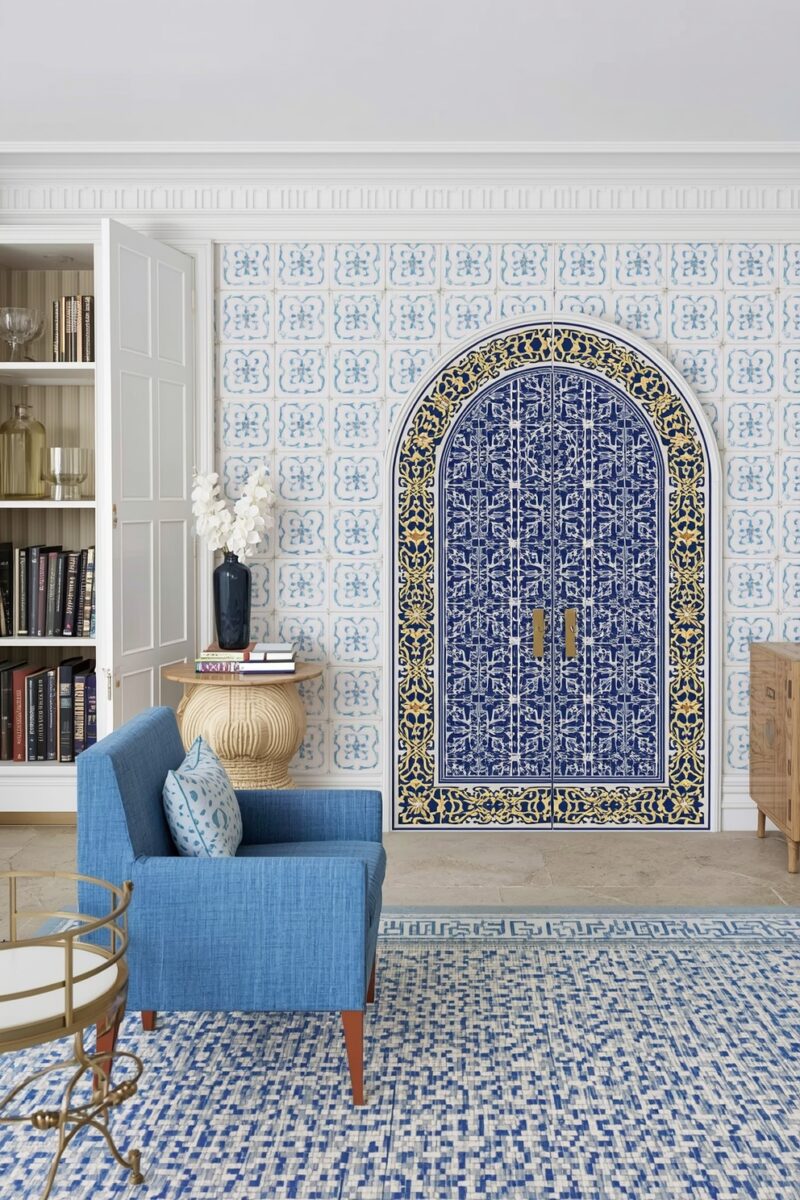 Mediterranean-inspired living room with ornate blue arched cabinet, tiled wallpaper, blue armchair, and gold accents