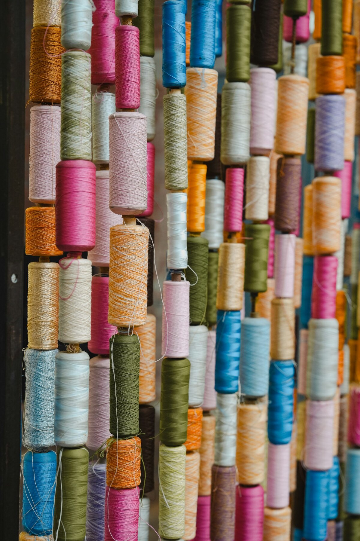 Rows of colorful cotton thread spools, the kind used to wrap string art